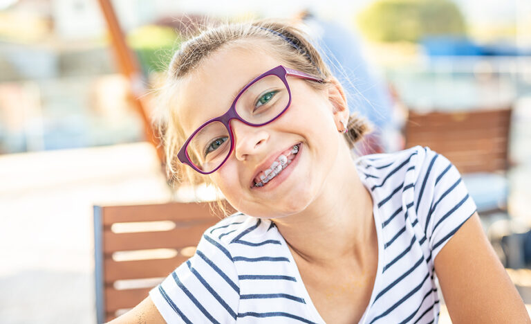 Young Preteen Girl In Glasses Wearing Braces Smiles At The Camer